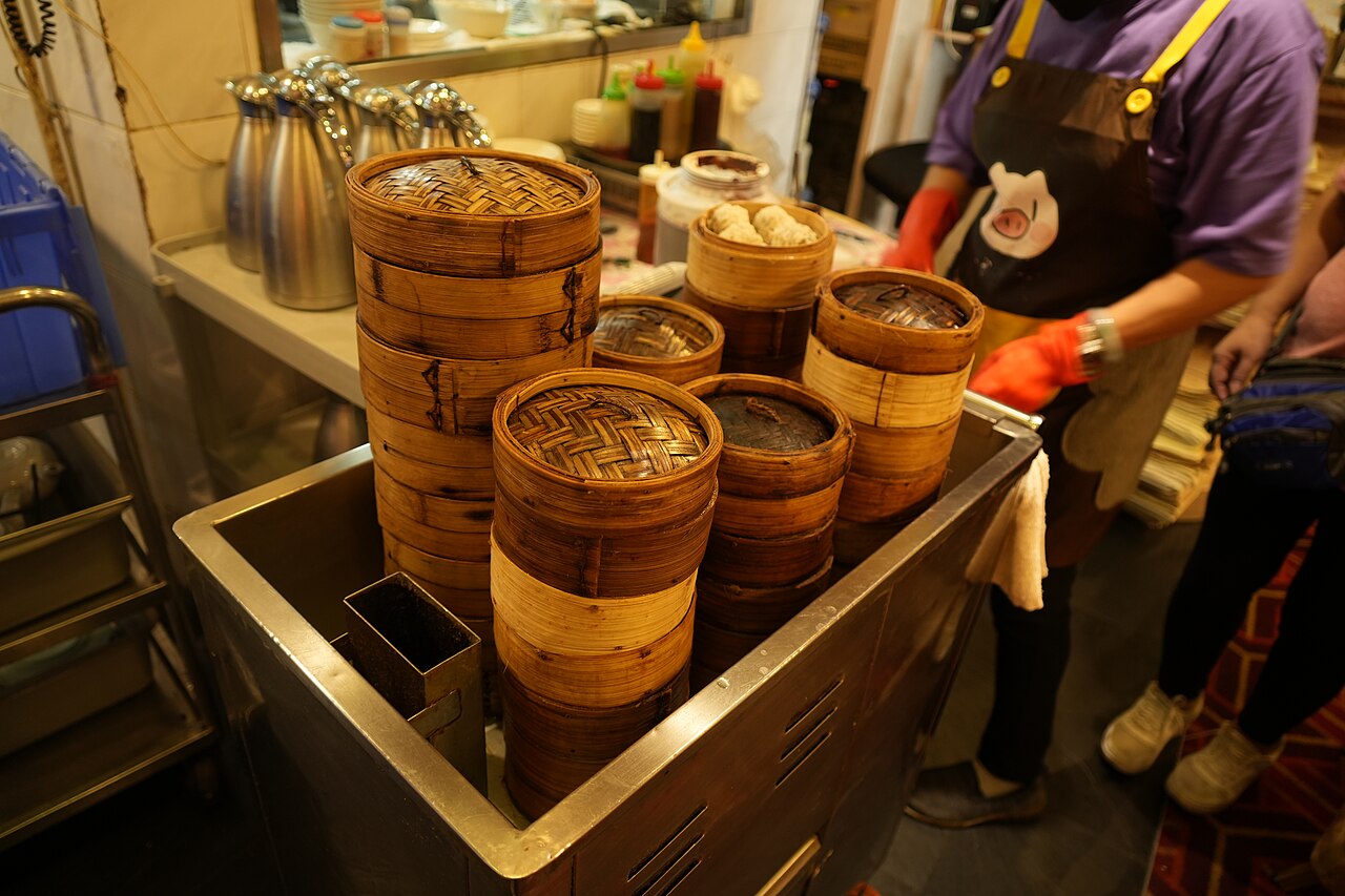 A traditional dim sum push-cart loaded with bamboo steamers at a Cantonese restaurant