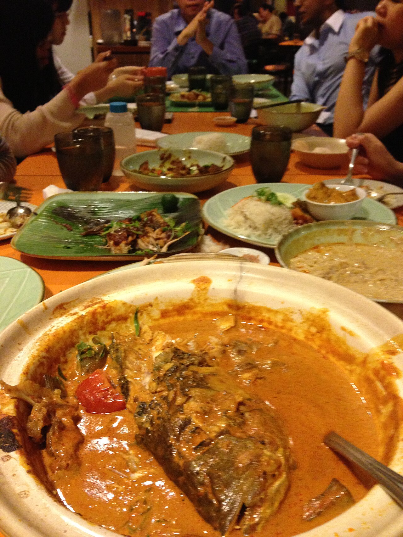 A large bowl of Singapore-style fish head curry with okra and tomato